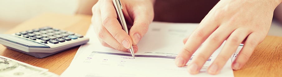 a person signing a piece of paper