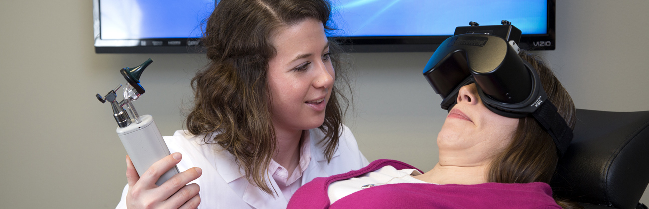 an audiologist explaining the causes of dizziness to a hearing patient