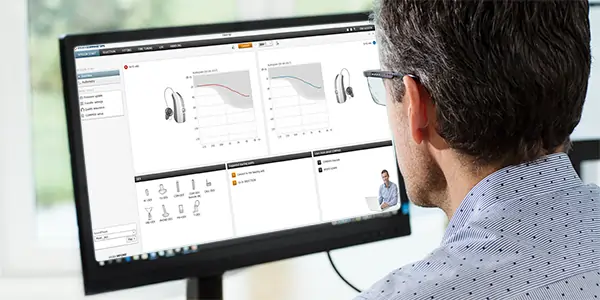 dispenser looking at computer screen in clinic