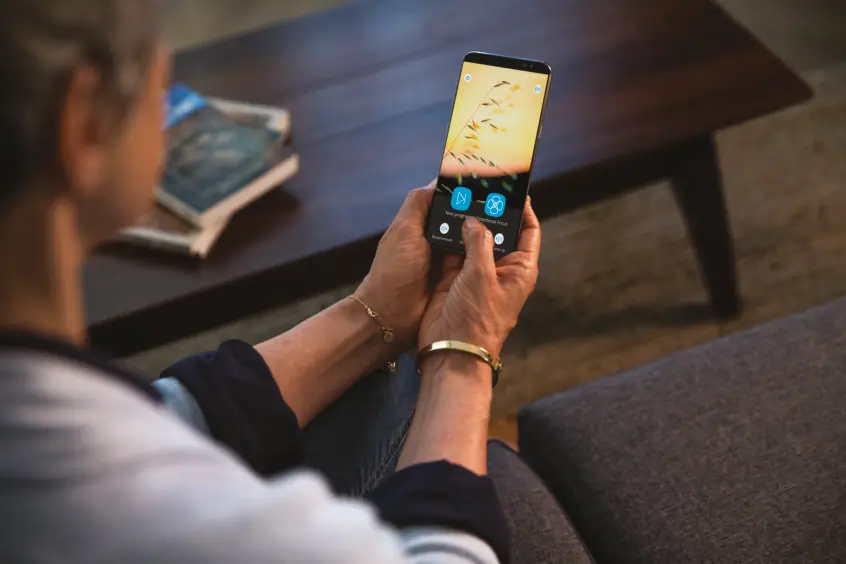 A person holding a phone while using the Anna Tonelink app.