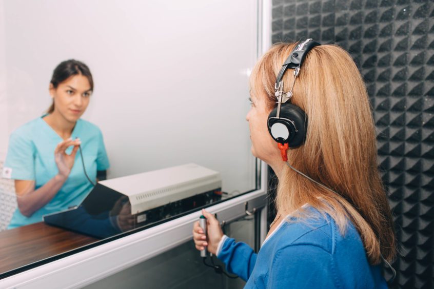 audiologist doing hearing test in special audio room