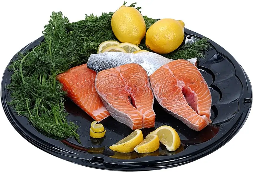 A plate of fresh salmon, dill, and lemon.