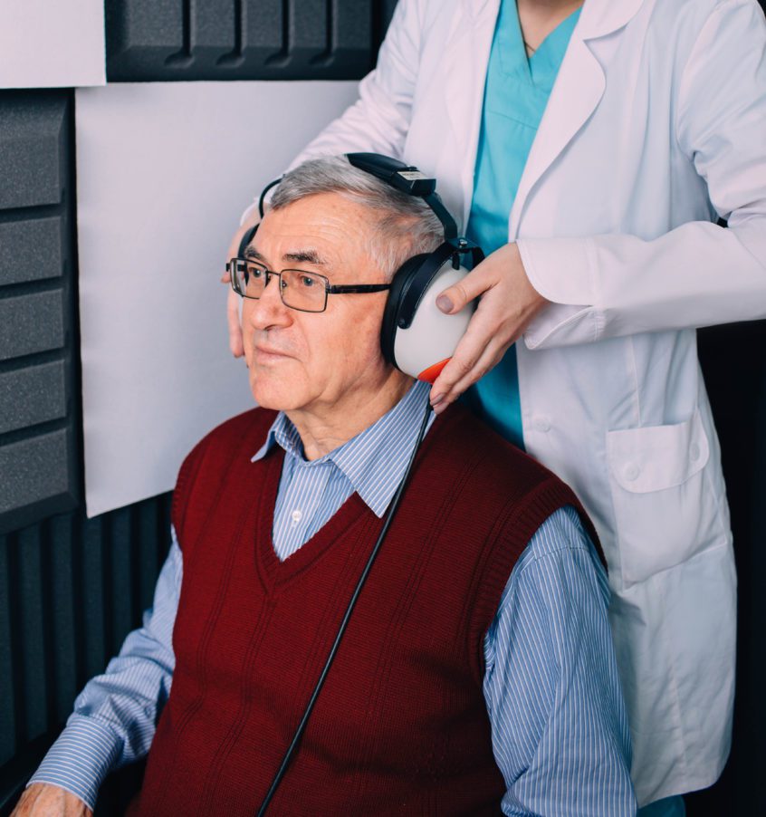 Senior man having hearing exam with special headphones