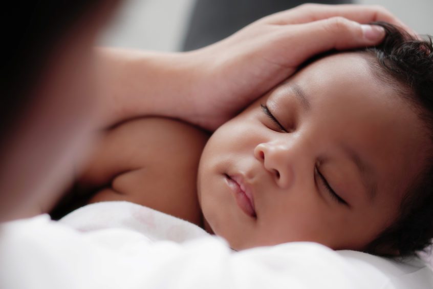 portrait of sleeping african american baby girl with mother