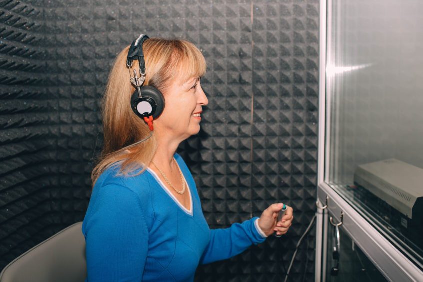 mature woman doing audiometry hearing exam
