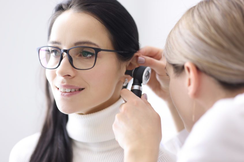 Doctor conducts ear examination for woman