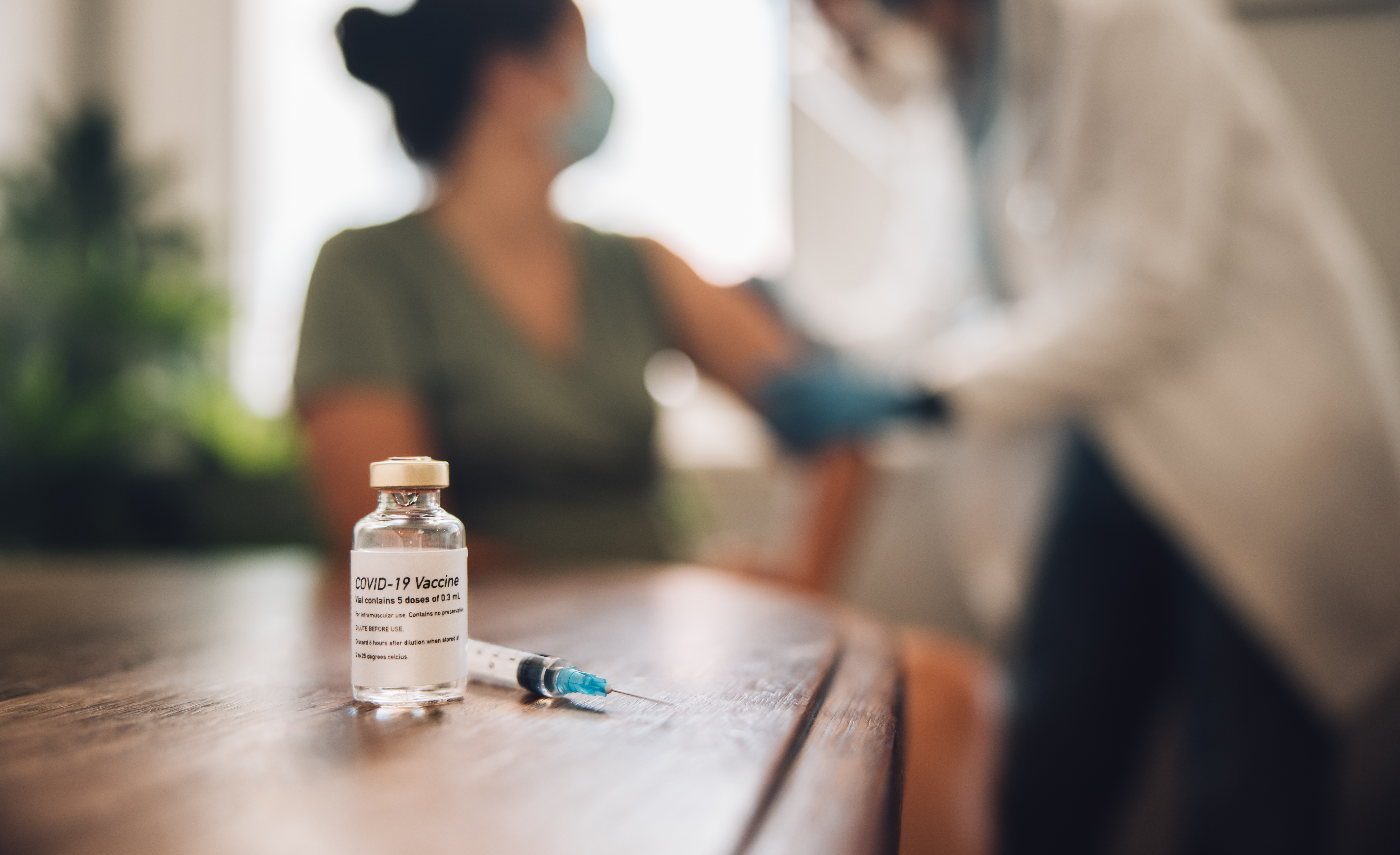 COVID 19 Vaccine with syringe on table