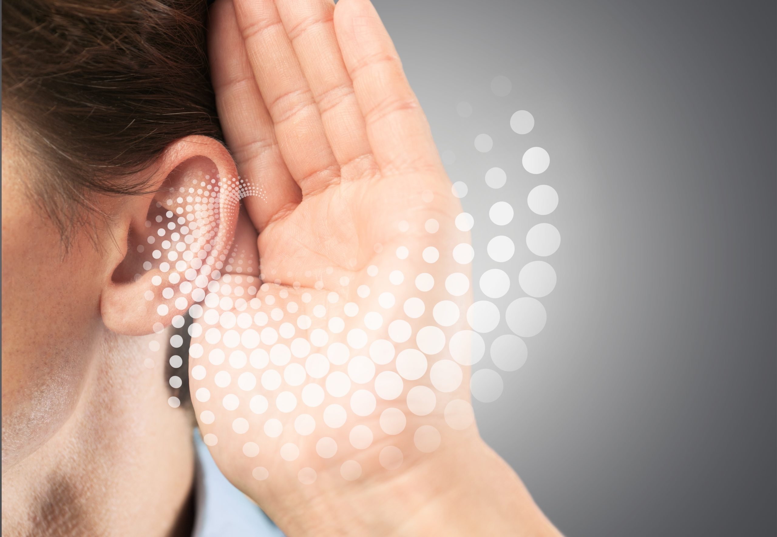 person with hand behind ear to amplify sound