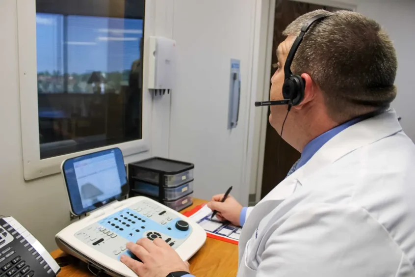 Associated Audiologists Independence, Travis Hopkins-Williams, Au.D. giving a hearing test, 2026