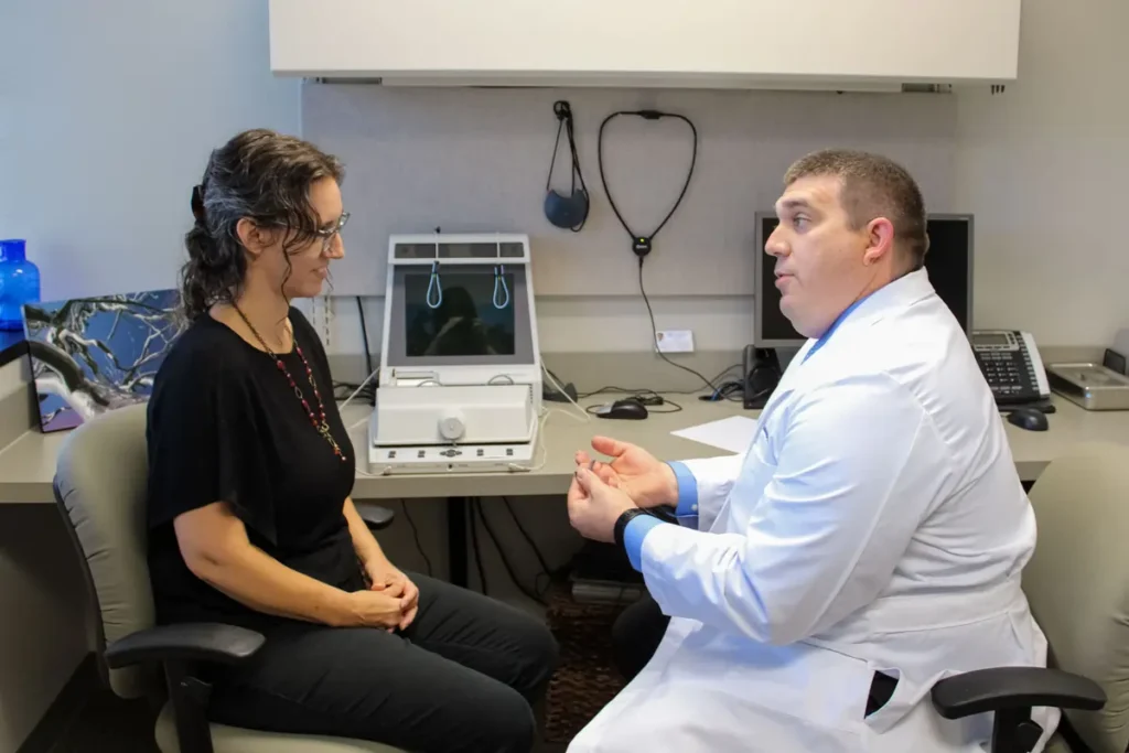 Dr. Travis Hopkins-Williams with a patient at Associated Audiologists of Independence, Missouri.